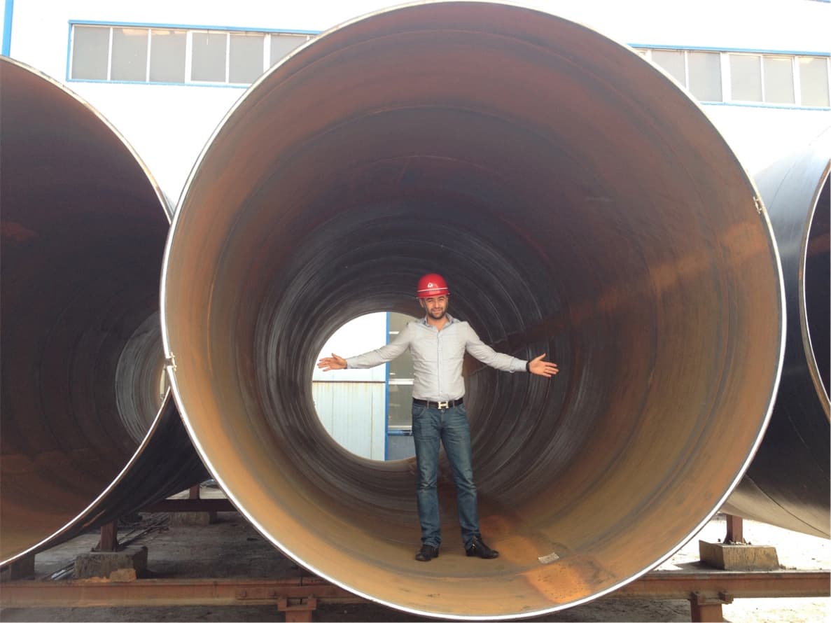 Persona dentro de una tubería gigante de acero.