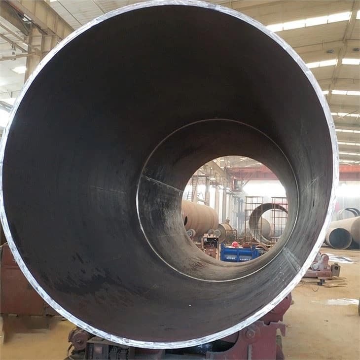 Vista del interior de una tubería de acero en un entorno industrial, mostrando el diámetro y el fondo de otras tuberías en el área.