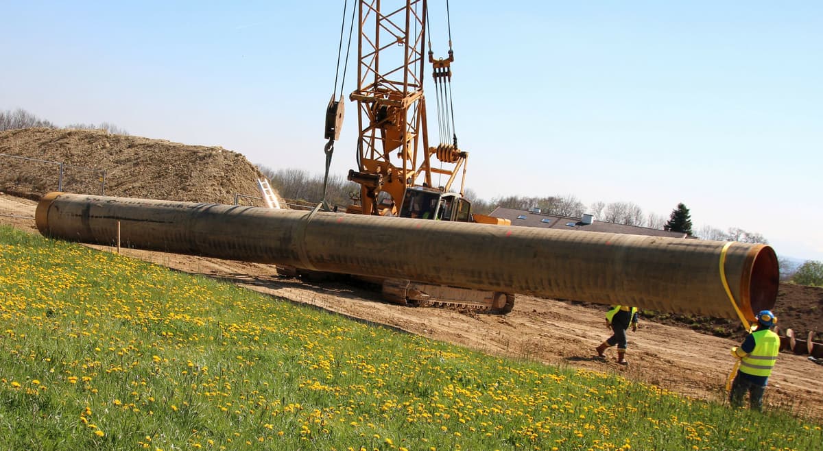 Instalando tubería gigante de acero para drenaje en un proyecto de construcción.
